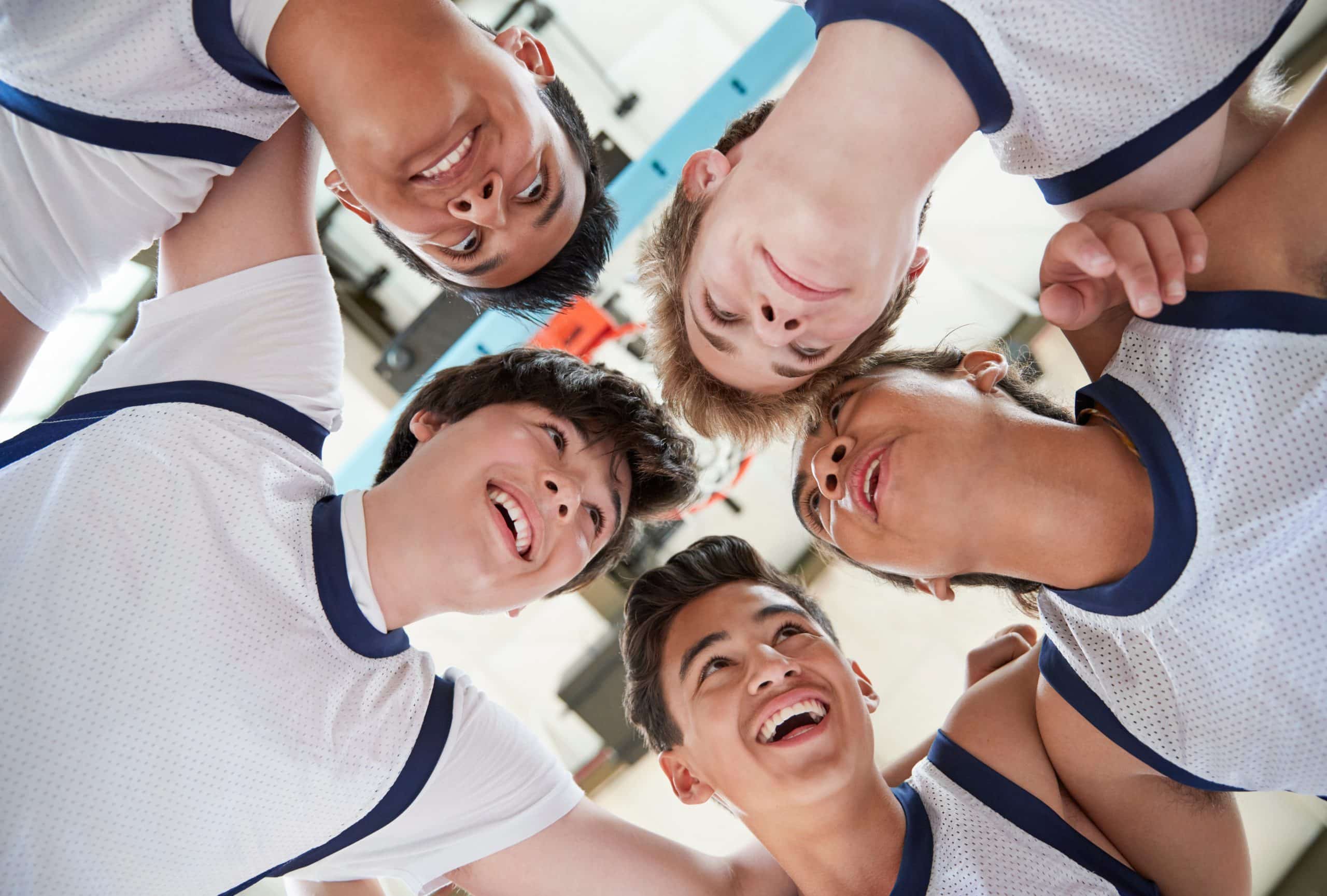 Low Angle View Of Male High School Basketball Players Having Team Talk